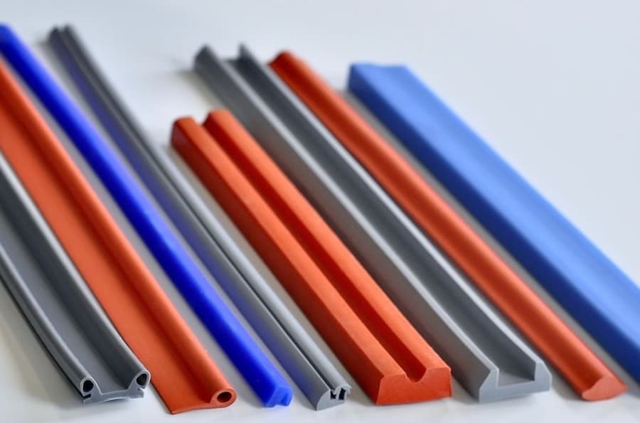 Assorted silicone rubber parts of varying colors and profile shapes resting side-by-side