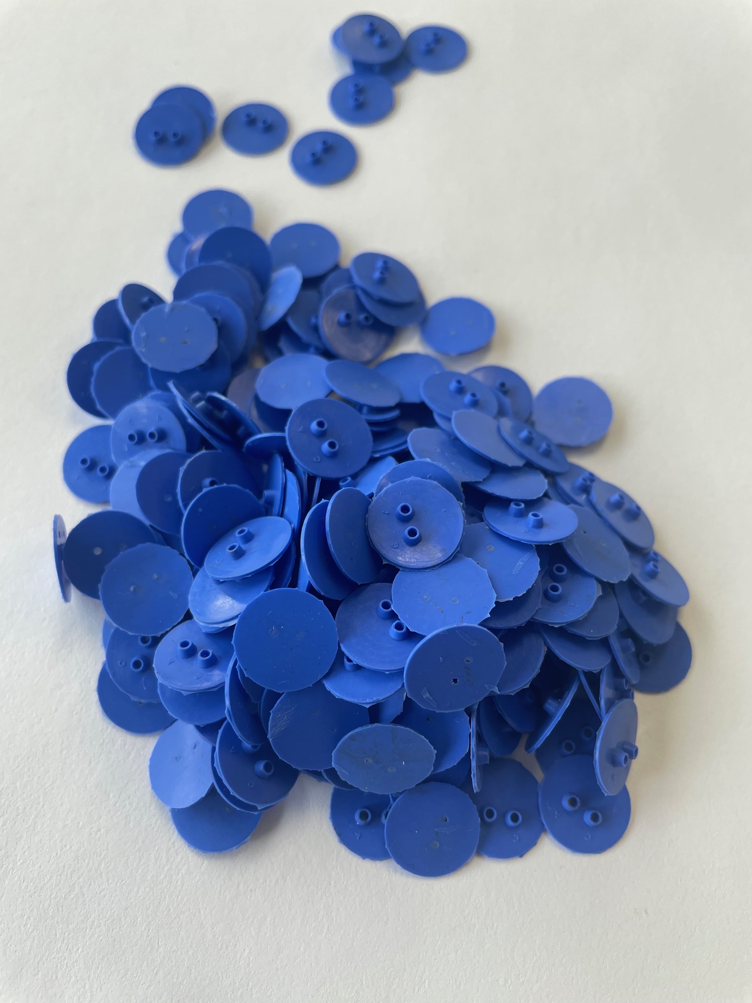 Pile of tiny blue molded rubber circles
