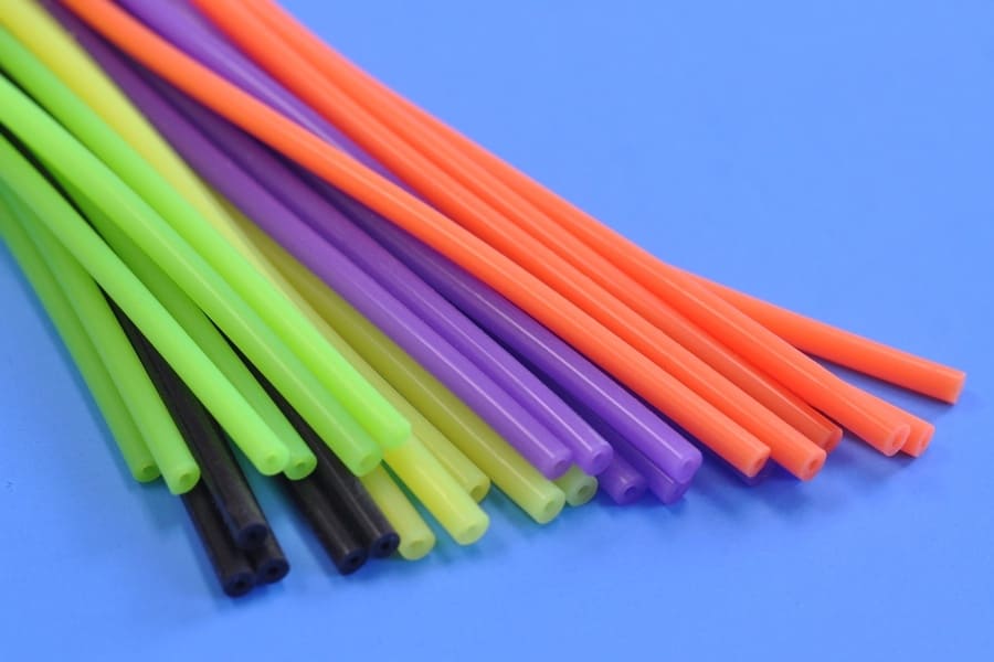 A bundle of small silicone rubber tubes of various colors including neon, black, purple, and orange