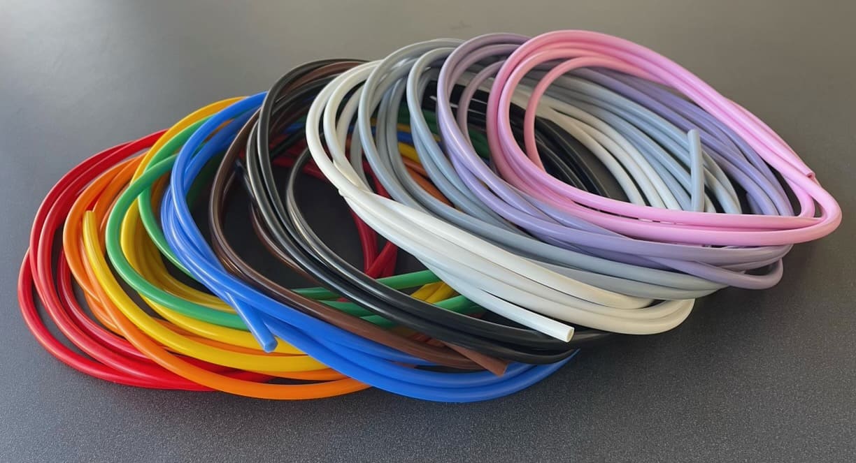 Multiple coils of small silicone rubber tubing stacked on top of one another. Each coil is a different color.