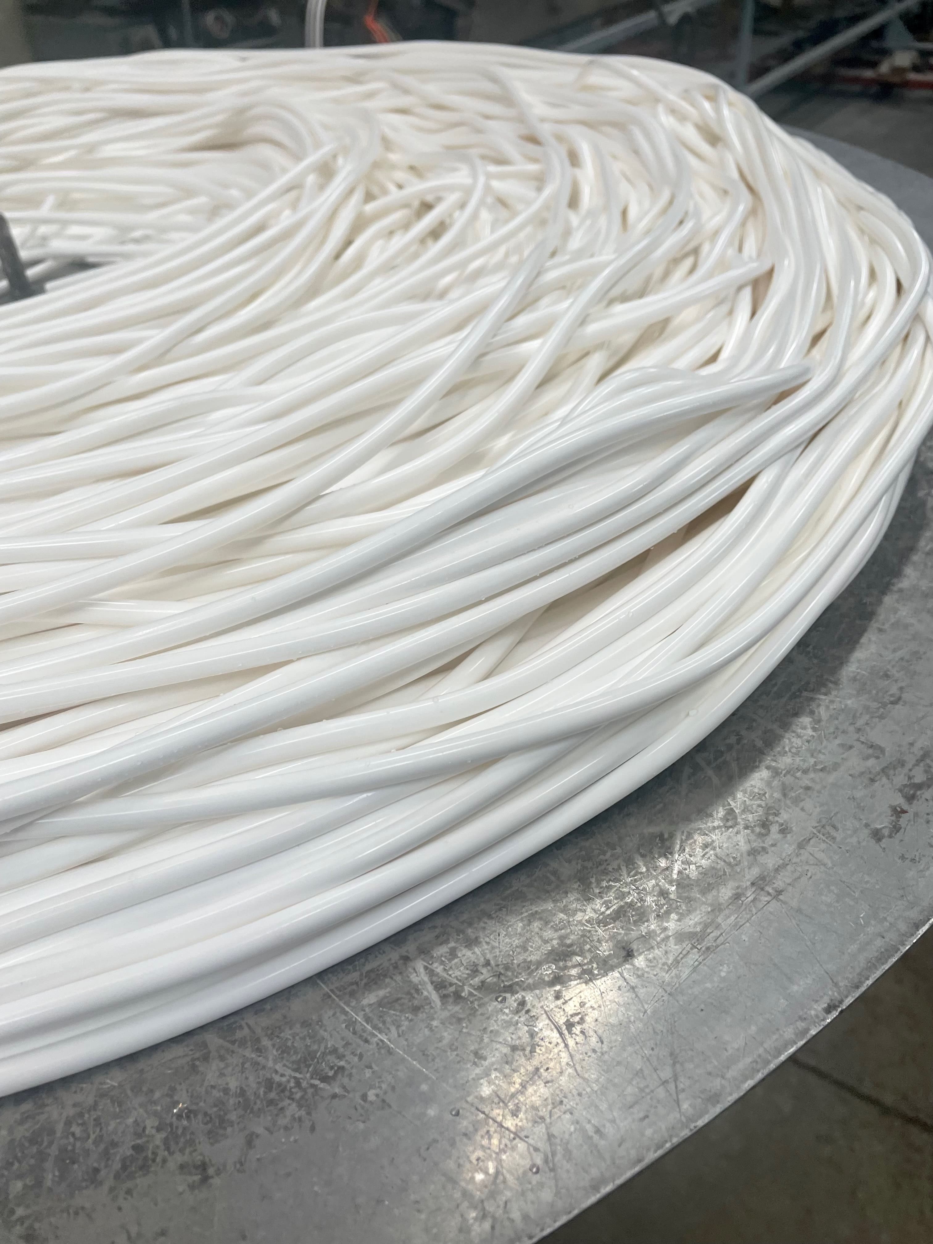 Thin, white silicone tubing sitting coiled up on a large spinner